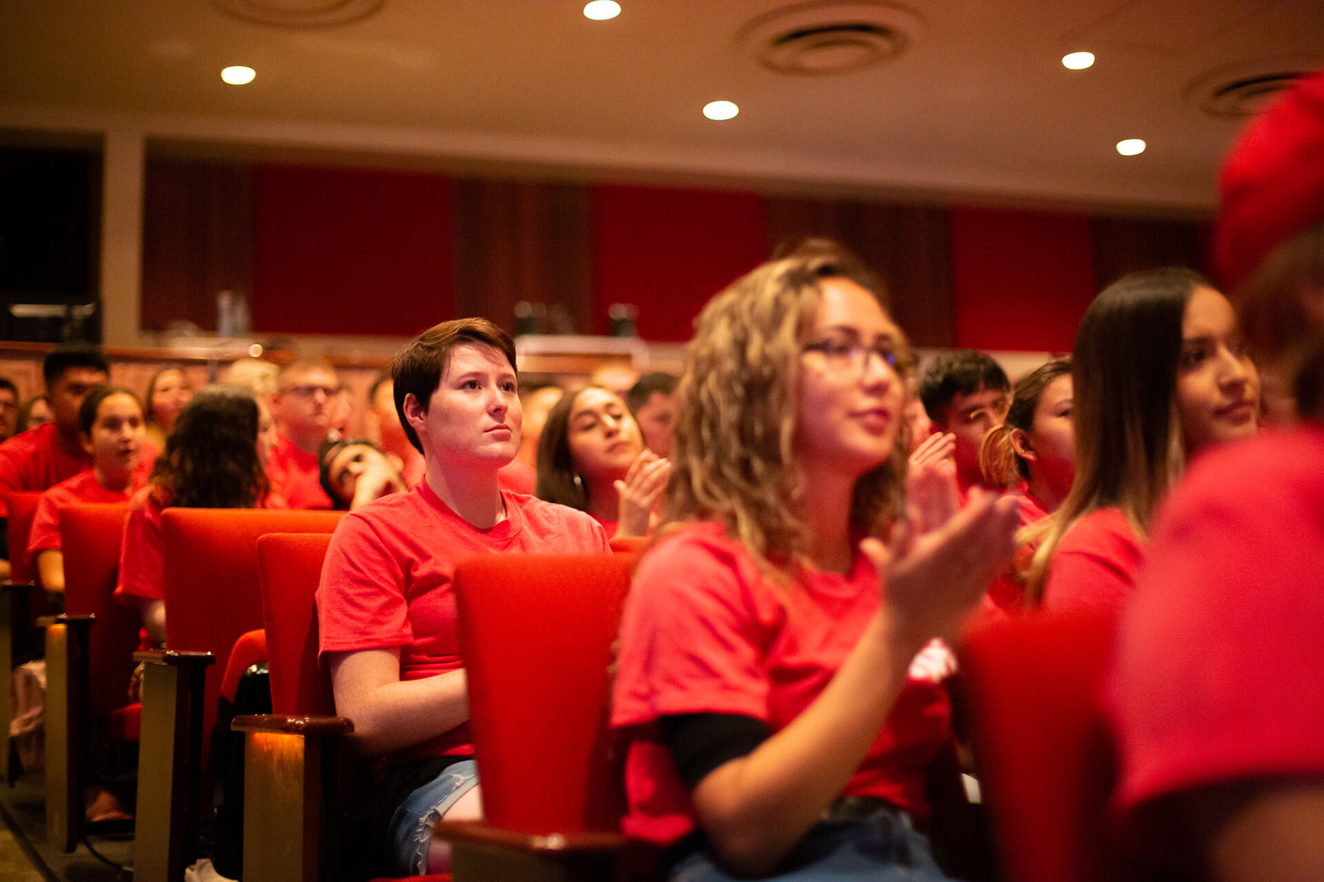 students in auditorium, image focused on one student